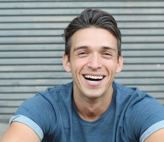 Portrait of handsome, happy male patient in dental treatment chair