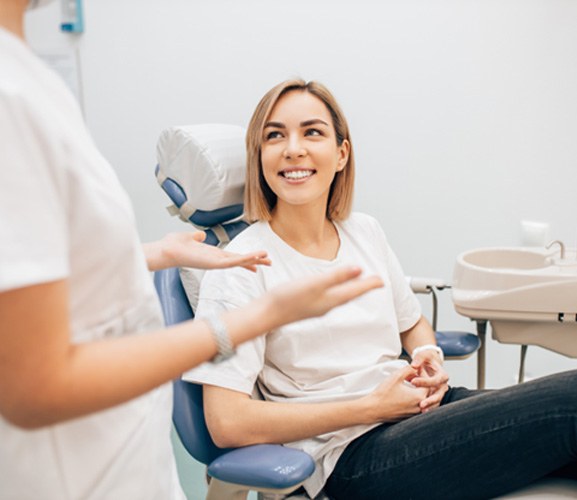 Smiling dental team member behind front desk