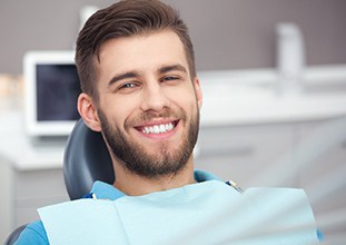 Man smiling while sitting in treatment chair