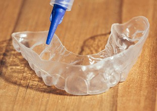 Teeth whitening tray and applicator on a wooden surface