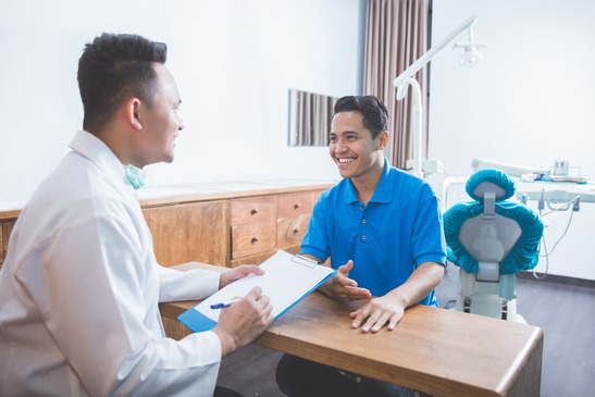patient talking to dentist about medical insurance 