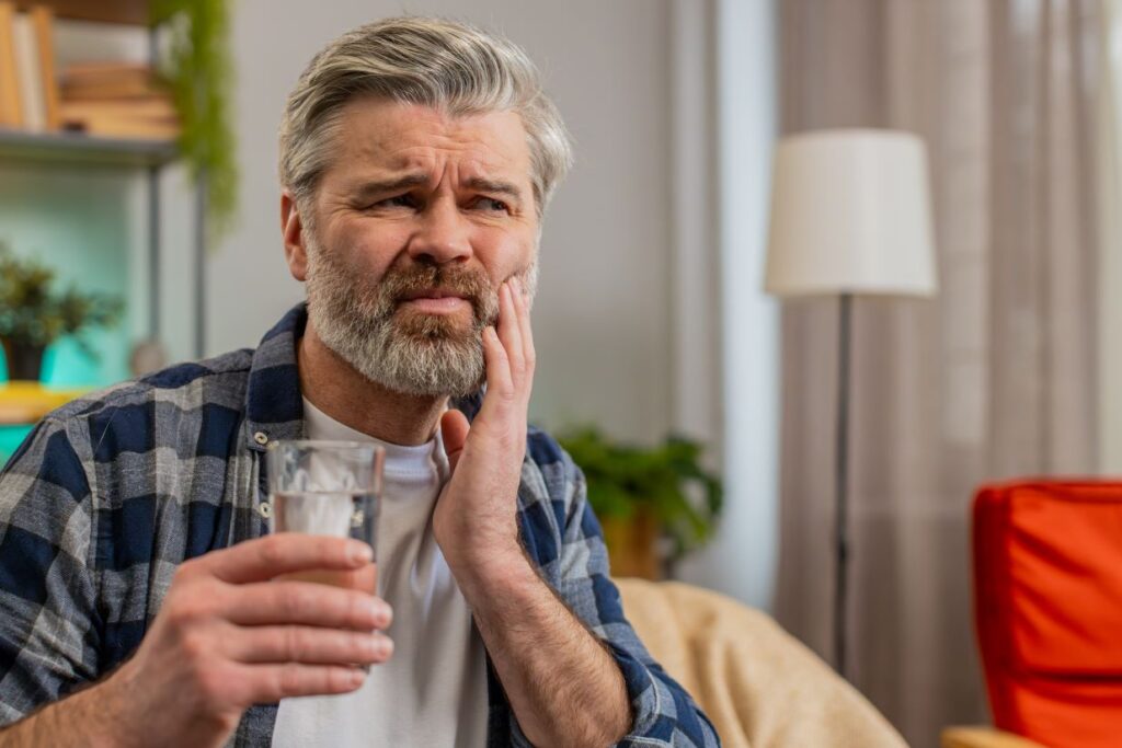 A man holding his jaw from tooth sensitivity